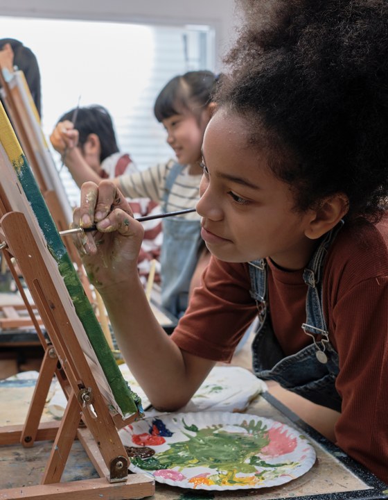 Children painting at easels during an art class